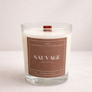 Bougie parfumée Sauvage de luxe dans son écrin noir minimaliste, notes orange ambre et mousse d'arbre.