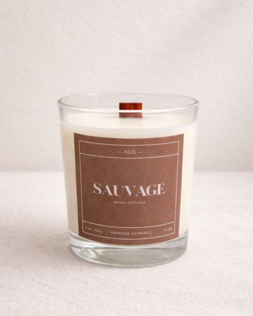 Bougie parfumée Sauvage de luxe dans son écrin noir minimaliste, notes orange ambre et mousse d'arbre.