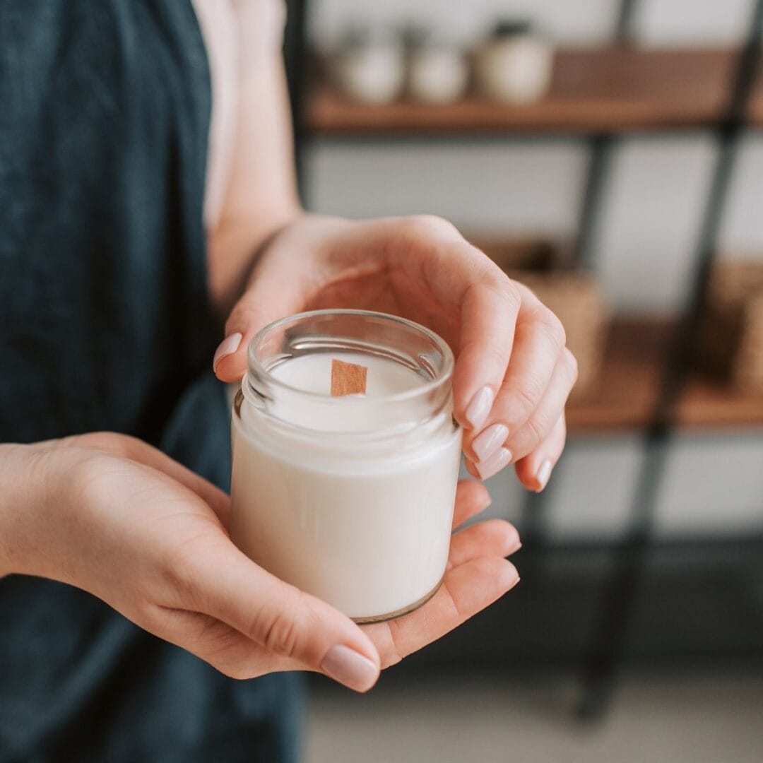 Une cliente tenant une bougie parfumée naturelle de Niõ en cire de colza - nos cires végétales et naturelles - Niõ