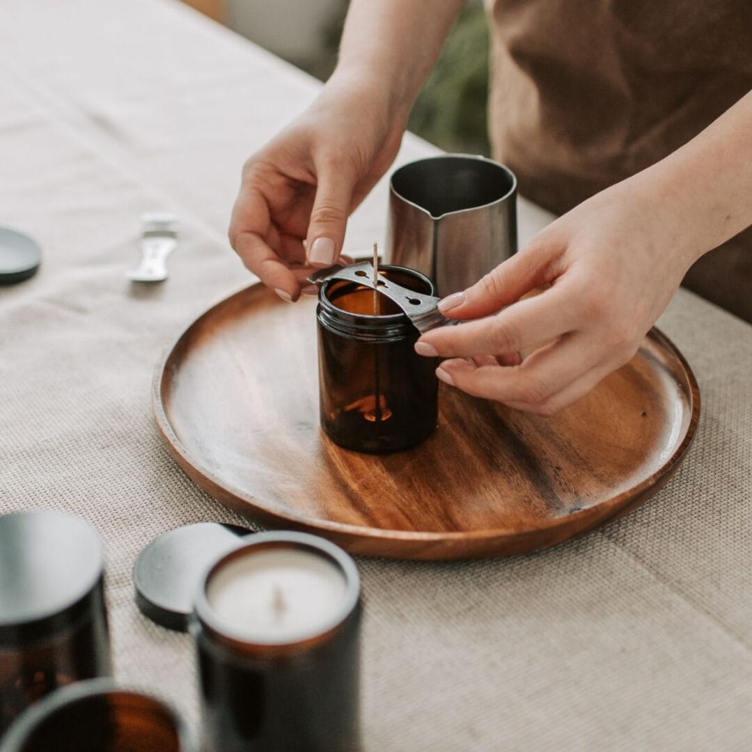 Flo, créatrice de Niõ en train de fabriquer à la main une bougie parfumée dans un contenant en verre  - illustration fabrication artisanale fait main - Niõ