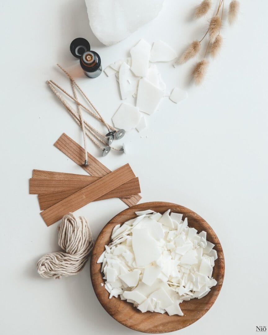 Image représente un récipient avec la cire de soja, les mèches en coton et en bois, un brin de la lavande séchée, une fiole de fragrance, représentant le savoir-faire et matières de Niõ